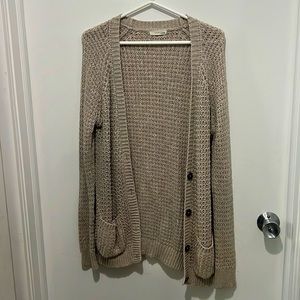 Beige cardigan/sweater with buttons.